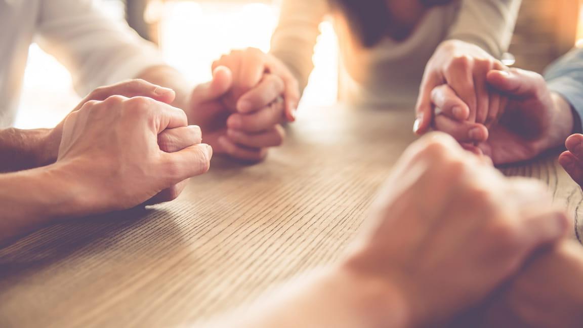 close up of friends holding h和s in a circle