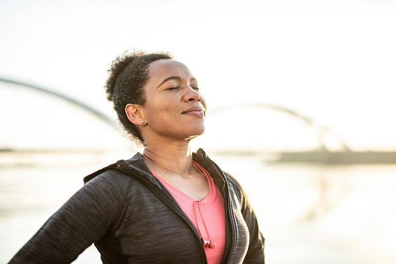 woman listening outdoors with eyes closed