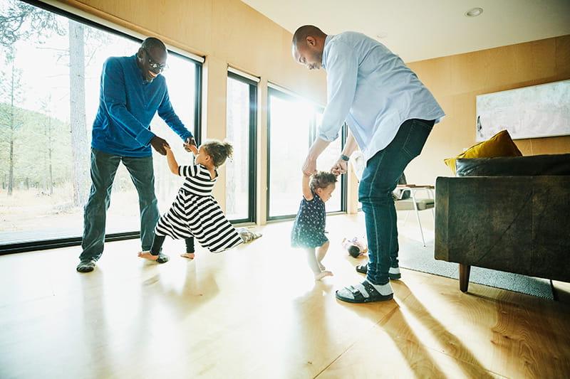 Grandfather father dancing with daughters at home