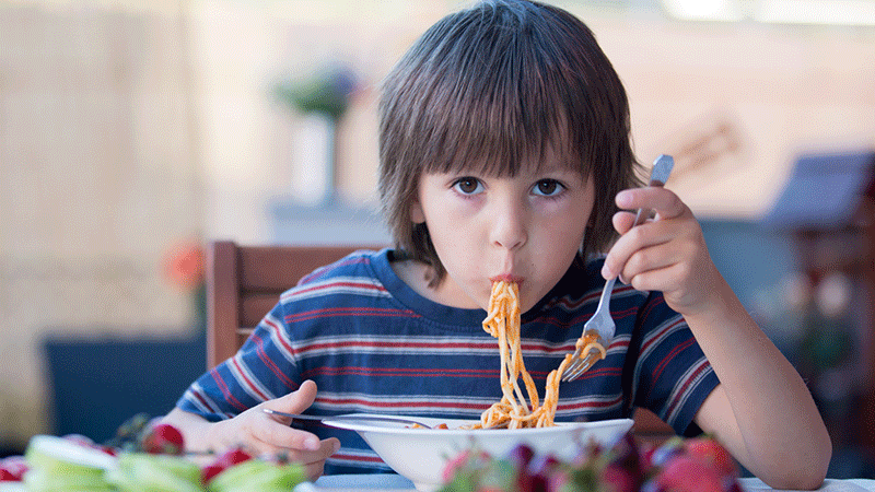 Boy eating spaghetti