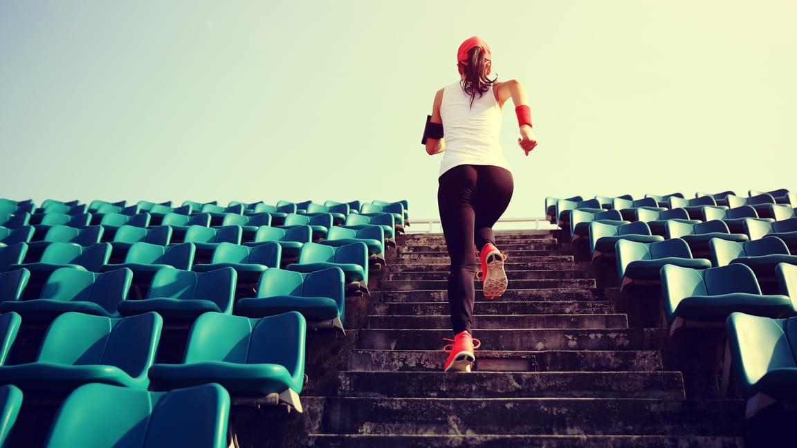 woman running up stadium stairs