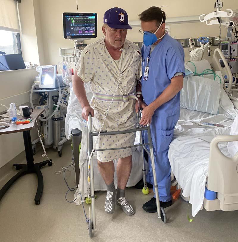 TA physical therapist helps Mark Wangrin (right) use a walker in his hospital room. (图片来源:Mark Wangrin)